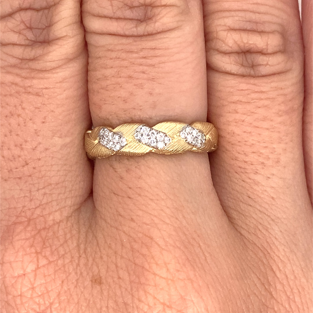 Textured gold ring with round brilliant diamond accents on hand