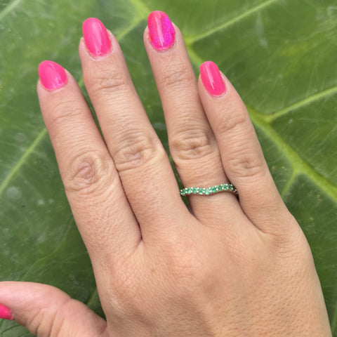Custom white gold emerald band worn on hand