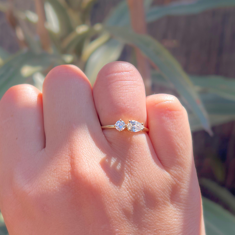 Custom Toi et Moi diamond ring worn on hand, yellow gold two-stone design.