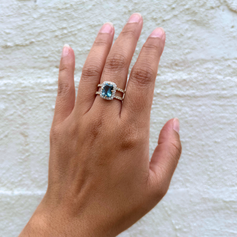 Santa Maria aquamarine ring worn on hand, showcasing vivid blue cushion-cut gemstone and diamond halo.