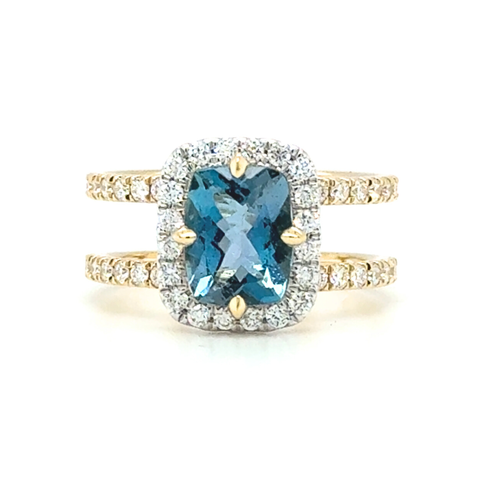 Santa Maria aquamarine ring featuring a cushion-cut blue gemstone with diamond halo set in 18kt yellow gold. 