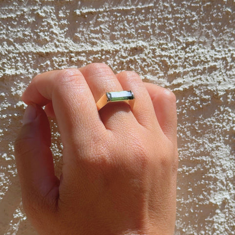 Tourmaline ring highlighting elongated emerald cut design worn on hand