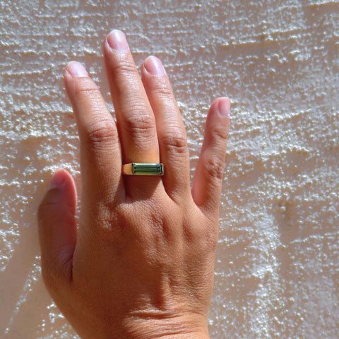 Green tourmaline gemstone yellow gold ring worn on hand 