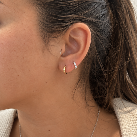 Small 9kt yellow gold huggie earrings worn