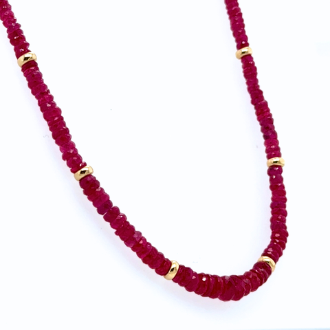 Burmese ruby strand necklace with natural rondel-cut rubies and 14kt gold rondels displayed on white background