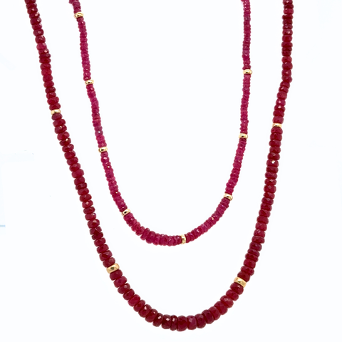 Two red bead necklaces with gold accents on a white background