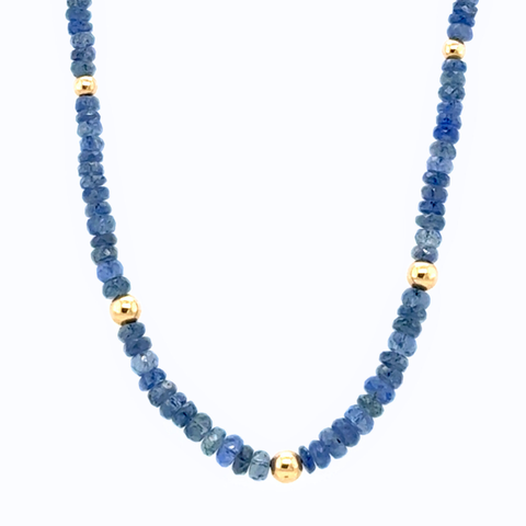 Full-length Burmese sapphire beaded strand with gold accents, displayed on white background.