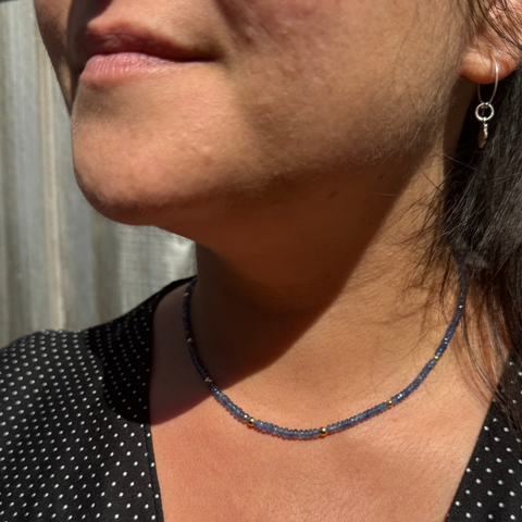 Side profile of model wearing Burmese sapphire strand, refined handcrafted gemstone necklace.