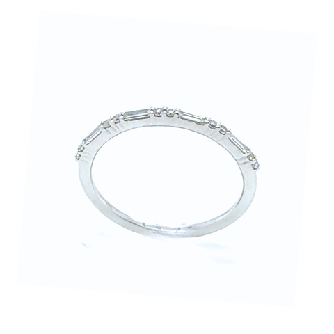 Baguette and round diamond white gold band displayed on shell in soft natural light