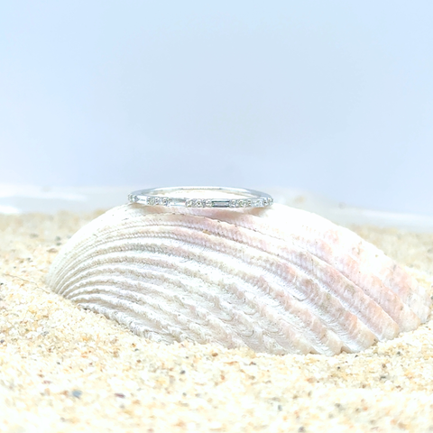 Side view of white gold diamond band with alternating baguette and round brilliant diamonds