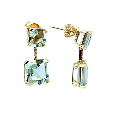 Gold earrings with green gemstones on a white background