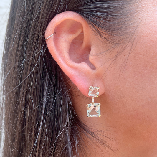 Close-up of an ear wearing a square-shaped earring with a blurred background