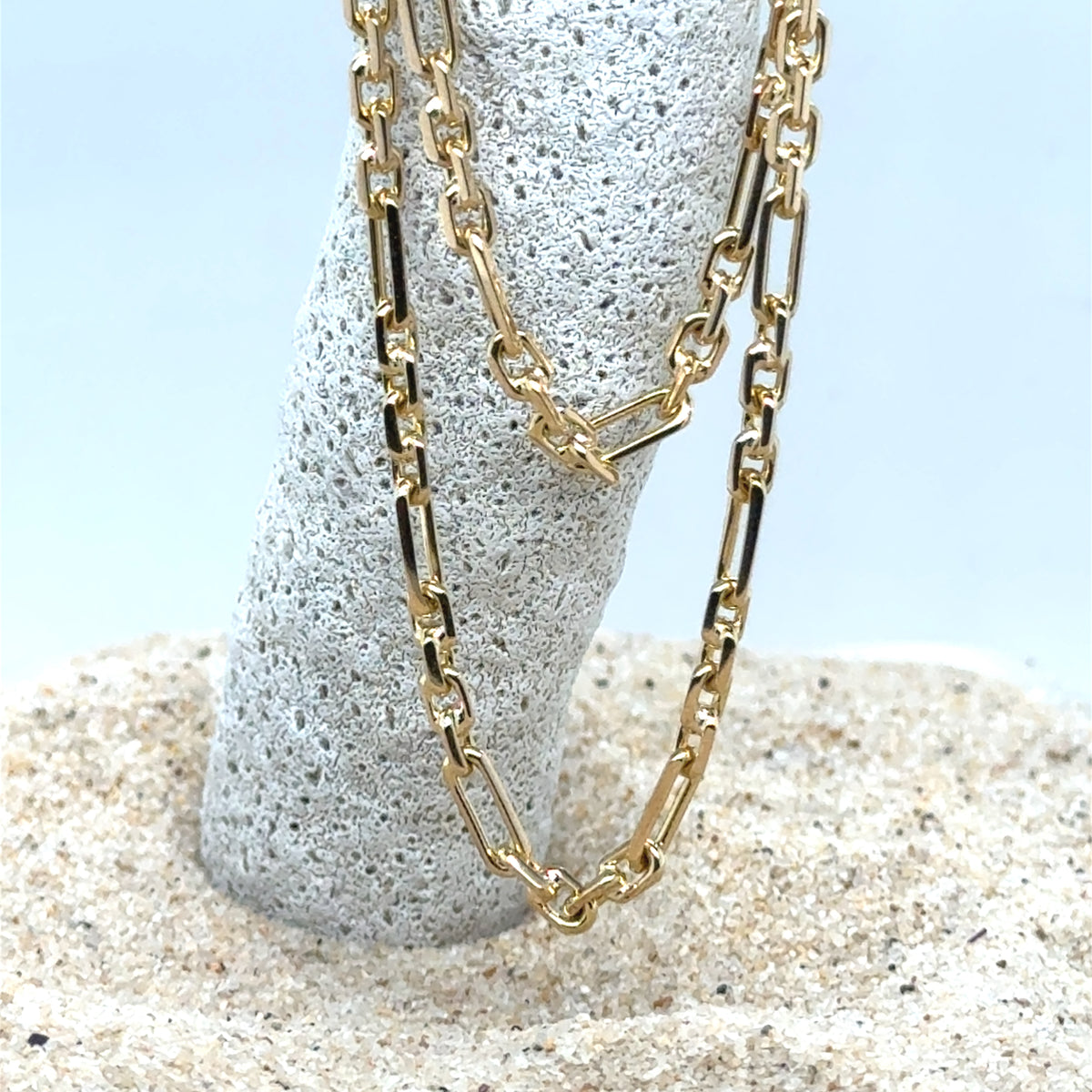 Close-up of Figaro link gold chain showing polished finish
