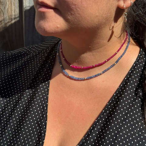 Burmese sapphire strand necklace worn on model, elegant deep blue gemstone beads with 14kt gold details.