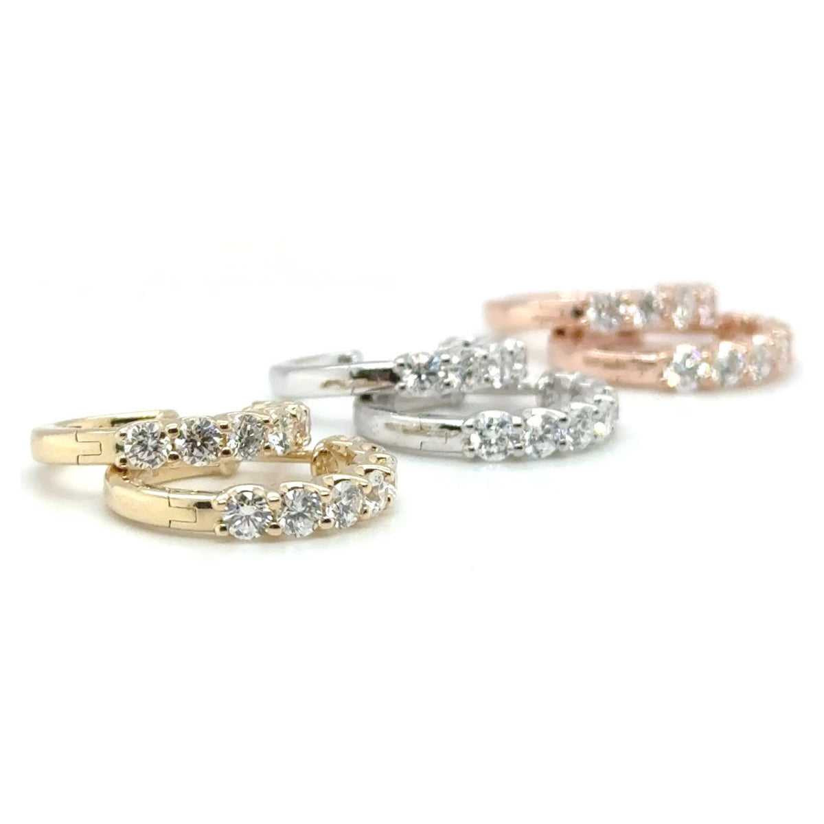 Diamond huggie earrings in mixed 14kt gold tones displayed with round lab grown diamonds