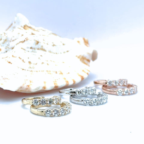 Diamond huggie earrings in mixed 14kt gold tones displayed with round lab grown diamonds.