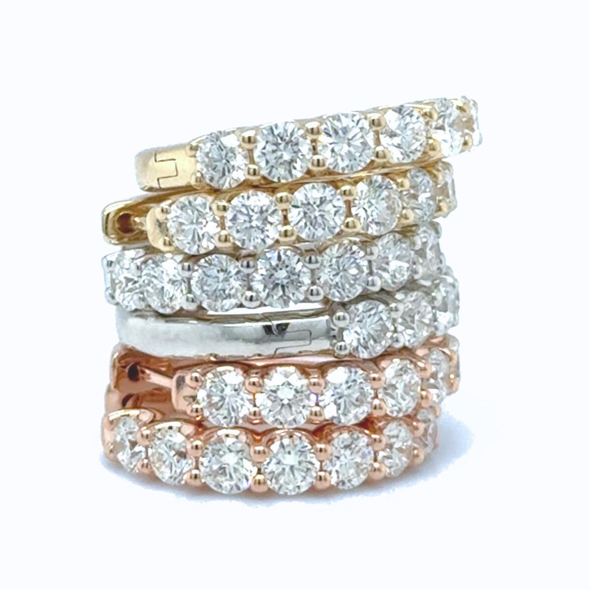 Assorted diamond huggie earrings in yellow, white and rose gold with round lab grown diamonds.