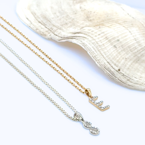 Diamond initial pendant necklace layered on chain