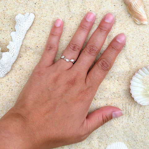 Delicate leafy diamond band in 18kt white gold shown worn outdoors