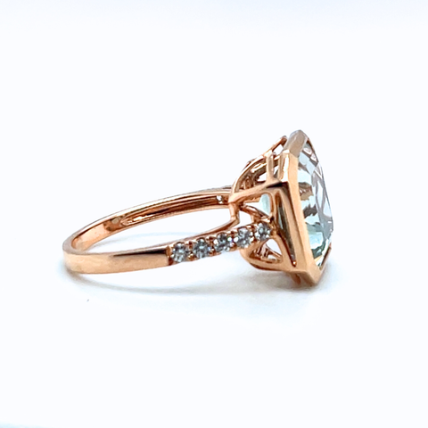 Rose gold ring with a large diamond and smaller diamonds on a white background