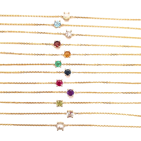 Birthstone bracelets in 9kt gold with genuine gemstones displayed in multi-colour flatlay.
